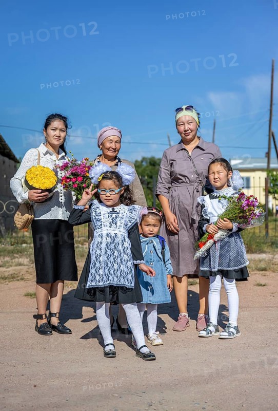 Family and schoolgirl with a bouquet of flowers on the first day of school, Issyk-Kul region, Kyrgyzstan, Asia