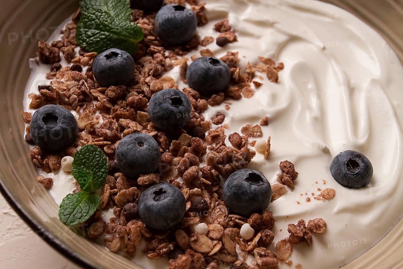 Yogurt with chocolate muesli, with berries, blueberries, breakfast, close-up, fork on top, no people