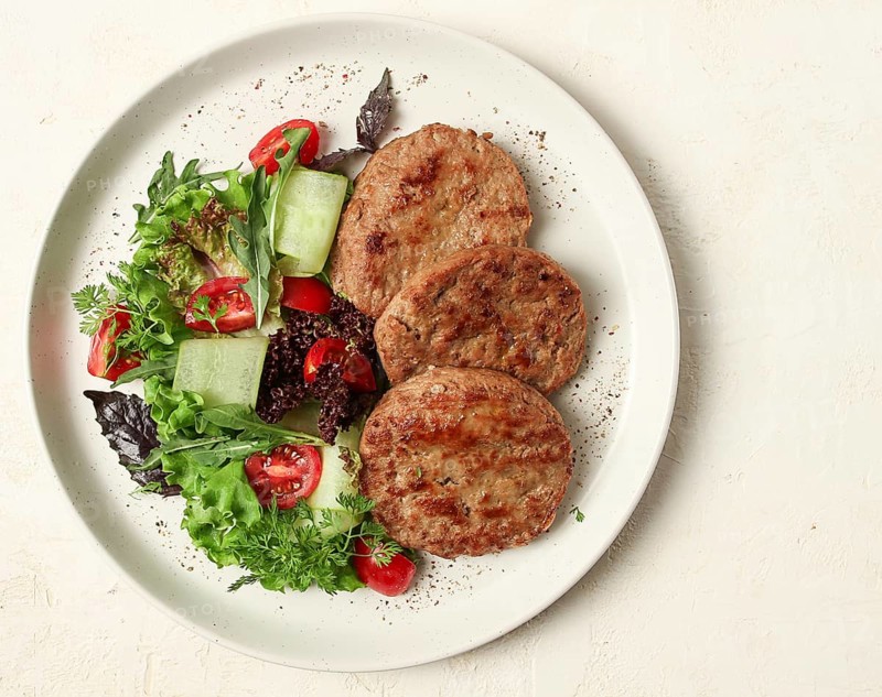 Fried cutlets, minced beef, with vegetable salad, top view, no people