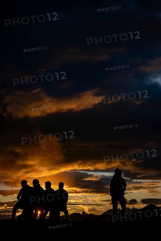 People marvelling at Montafon mountains with dramatic cloudy sky at sunset, Tschagguns, Rätikon, Montafon, Vorarlberg, Austria, Europe