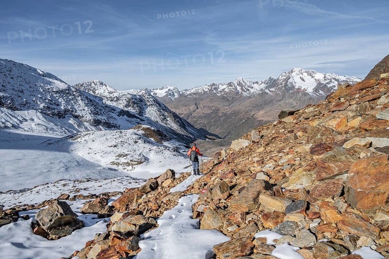 Mountaineer in autumnal mountain landscape with snow, mountain panorama in autumn with summit Wildspitze, view of the Weißkamm, Ötztal Alps, Tyrol, Austria, Europe