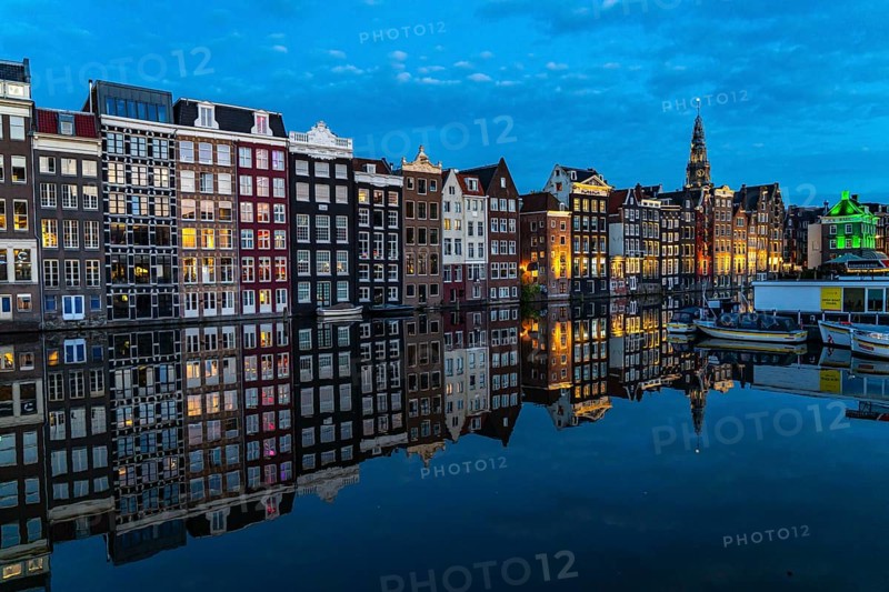 Canal houses on the Damrak, in the centre of the old town of Amsterdam, harbour, starting point of many canal tours, in the evening, church tower of the Oude Kerk, Netherlands