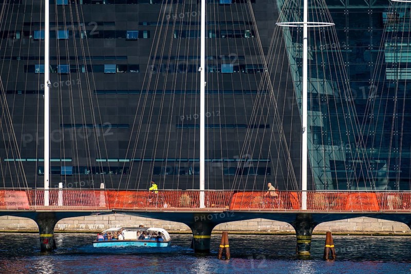 Cyclists on the Cirkelbroen cycle and footpath bridge, over the harbour, in the Christianshavens district, in the background the Danish Royal Library, Black Diamond, Copenhagen is considered the cycling capital of the world, 45 % of the population travel by bike, Denmark, Europe