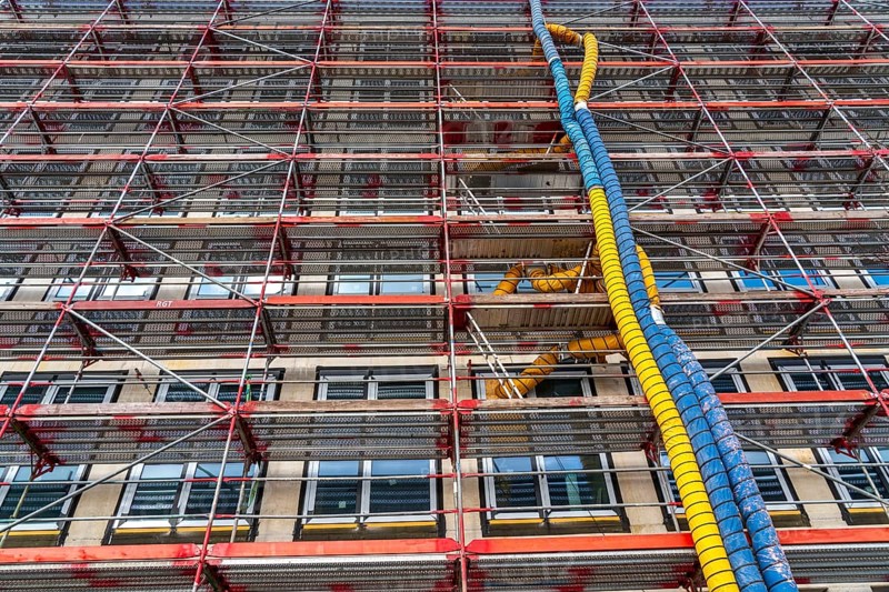 Large construction site, scaffolded shell of an office building complex, air hoses for building ventilation, heating, O-Werk Campus in Bochum, North Rhine-Westphalia, Germany, Europe