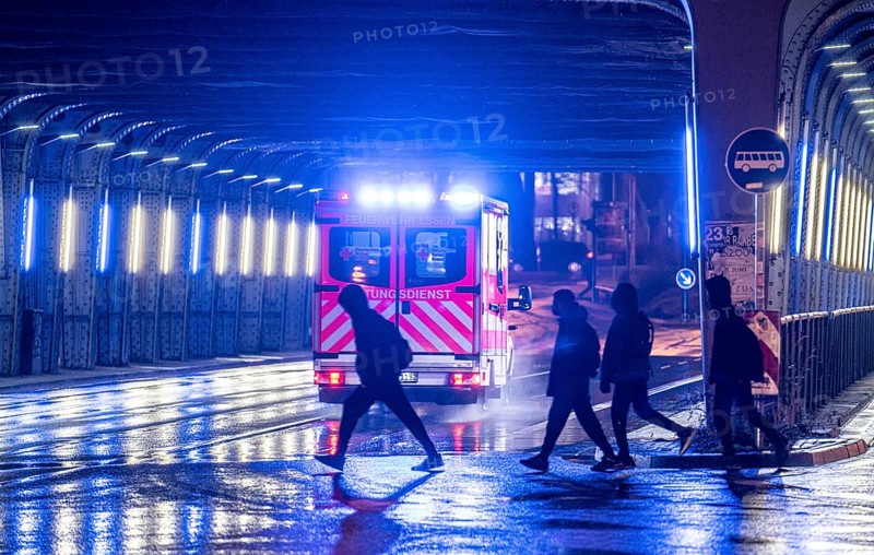Ambulance on alarm, DRK, Essen fire brigade, rainy weather, city centre, evening, Essen, North Rhine-Westphalia, Germany, Europe