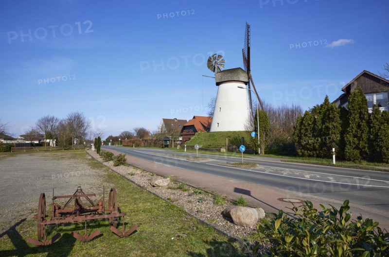 Windmill Hummelbecker Mühle under a cloudless blue sky, a Wall-Holländer, and a historical plough in the foreground is part of the Westfälische Mühlenstraße in Dützen, Minden, Mühlenkreis Minden-Lübbecke, North Rhine-Westphalia, Germany, Europe