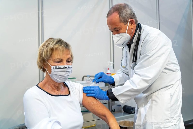 Vaccinator administers a vaccination, during the test run in the vaccination centre for corona vaccinations, in a hall at Messe Essen, by the city, the fire brigade and various aid organisations, 12 vaccination lines for a daily vaccination of up to 2400 people, operated by the North Rhine-Westphalia Association of Statutory Health Insurance Physicians