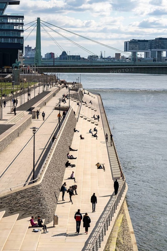 Effects of the coronavirus crisis, Rhine promenade, Rhine boulevard, on the Deutzer Ufer, few people with a lot of distance to each other in the spring sun, Cologne, Germany, Europe