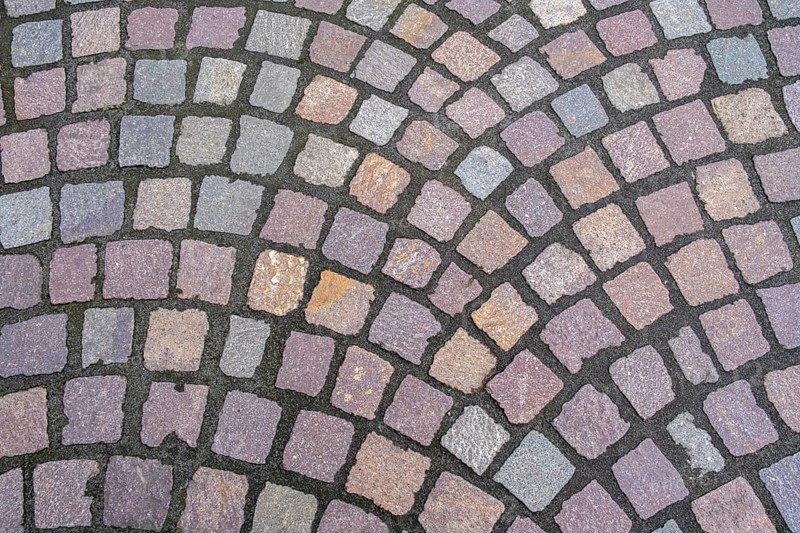 Pavement made of irregularly arranged, square paving stones in shades of grey, purple and brown, North Rhine-Westphalia, Germany, Europe