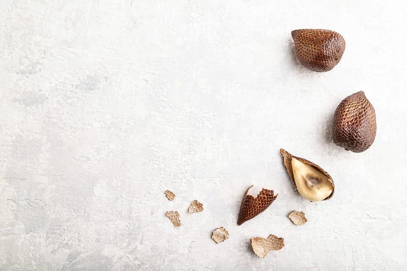 Salak or snake fruit on gray concrete background. Top view, flat lay, copy space. Tropical, healthy food, summer, exotic, minimalism