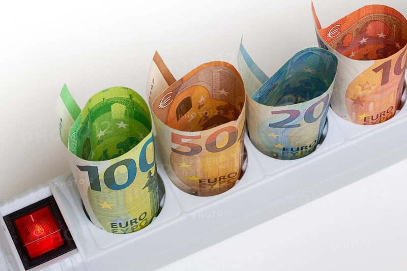Symbolic image of electricity costs: Multiple socket outlet with banknotes