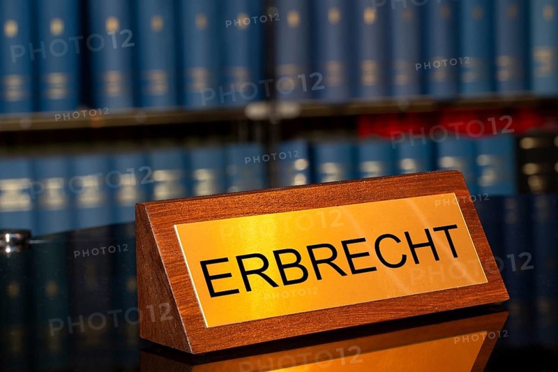 Symbolic image of inheritance law: Brass sign with the inscription Erbrecht in front of a large bookshelf (Composing)