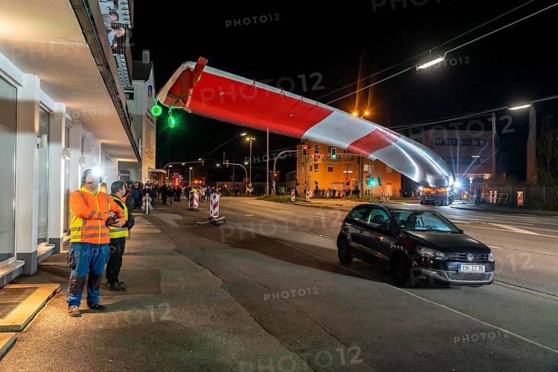 Transport of a 68 metre long, 22 tonne blade of a wind turbine, here in Schwelm, onlookers, with a self-propelled Blade-Lifter vehicle, over a 40 km long route, over 2 nights, in the Bergisches Land, through towns, villages, over country roads, narrow through roads, to the construction site of the wind turbine near Hagen, North Rhine-Westphalia, Germany, Europe