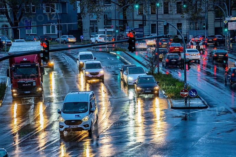 Rainy weather, road traffic, intersection, lights of vehicles on a wet road, traffic lights, tail lights, headlights, symbolic image