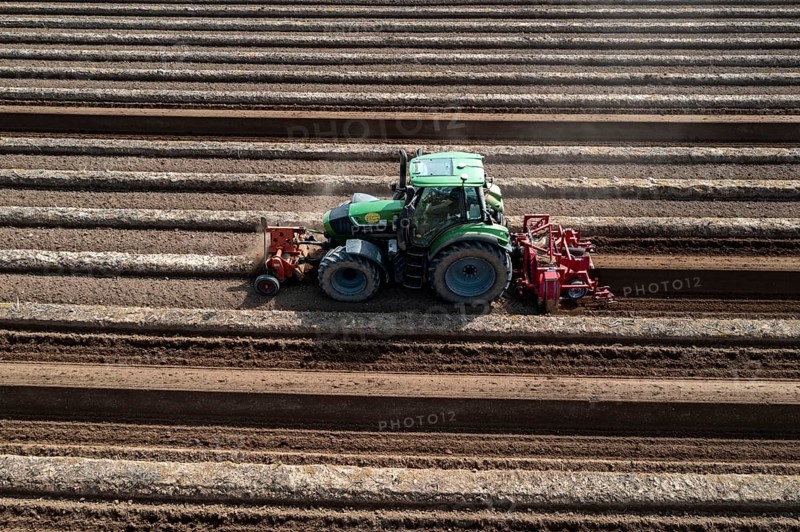 A farmer builds asparagus ridges on a field with the help of an asparagus tiller, in which the asparagus then grows, Dormagen, North Rhine-Westphalia, Germany, Europe