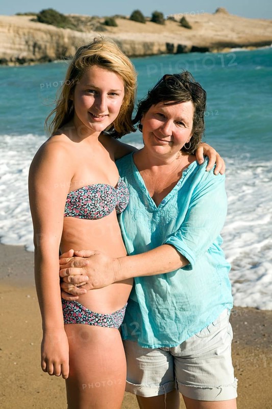 Model released mother and daughter embrace on holiday at the beach, Rhodes, Greece, Europe