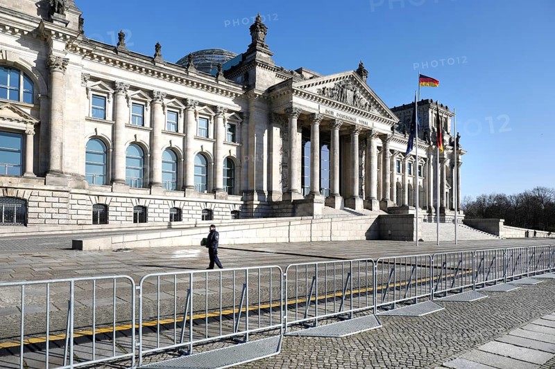 A policeman in front of the cordoned-off Reichstag in Berlin. Where many hundreds of people usually linger to visit the government district, there is now an eerie silence. Public life in Berlin has almost come to a standstill following the protective measures recently adopted to prevent the spread of the coronavirus. All sights, museums, squares, streets, restaurants, universities, 23.03.2020 are affected