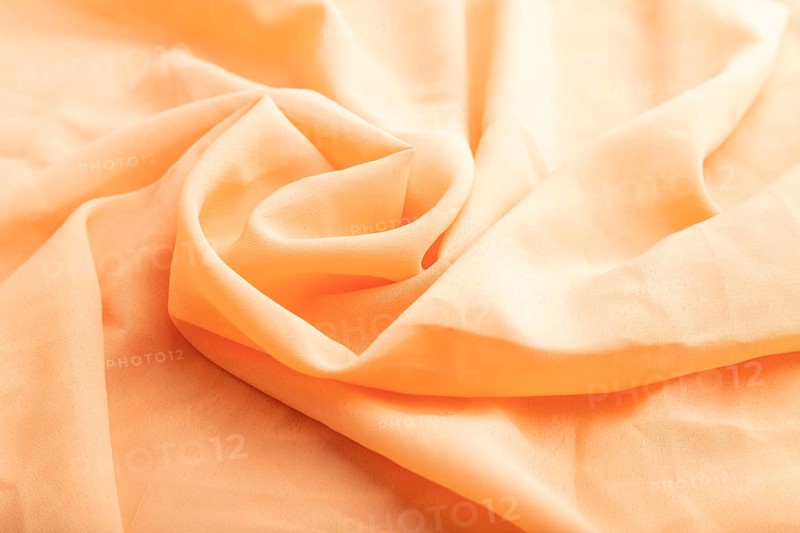 Fragment of orange linen tissue. Side view, natural textile background and texture. wave concept, abstract, spiral form