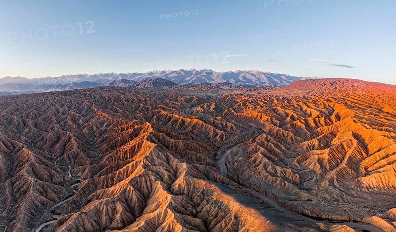 Riverbed in a landscape of eroded hills, badlands at sunrise, Issyk Kul Lake in the background, aerial view, Canyon of the Forgotten Rivers, Issyk Kul, Kyrgyzstan, Asia