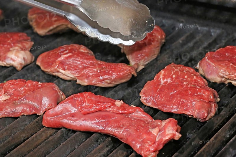 Raw steak on the grill