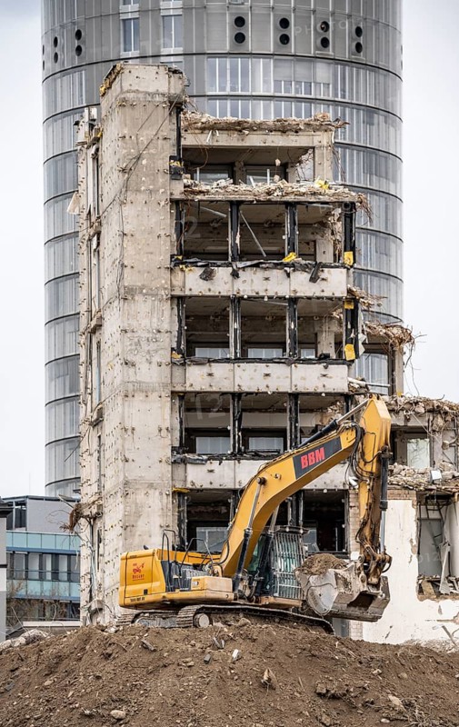 Demolition of the former RWE building complex, in the city centre, on the A40 motorway in Essen, excavator working on the piles of rubble, in the background the RWE Tower, North Rhine-Westphalia, Germany, Europe