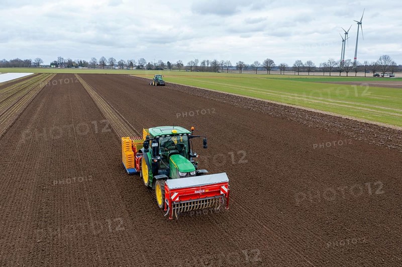 Lettuce plants are planted with a planting machine, tractor with roundabout harrow prepares the soil, agriculture, spring