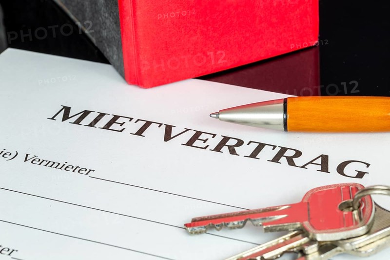 Symbolic image of rental agreement: close-up of a rental agreement and front door key
