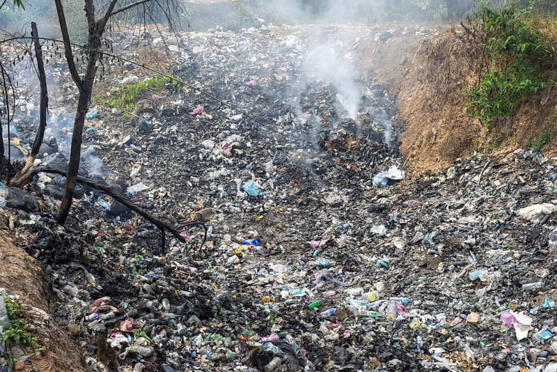 Coking rubbish dump, rubbish pit with waste and plastic rubbish, karst landscape near Vang Vieng, Vientiane province, Laos, Asia