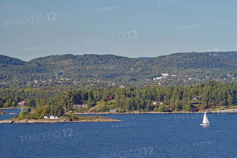 A lonely sailing boat near a small island, surrounded by water and with wooded hills in the background, Oslofjord, capital city, Oslo, Norway, Europe