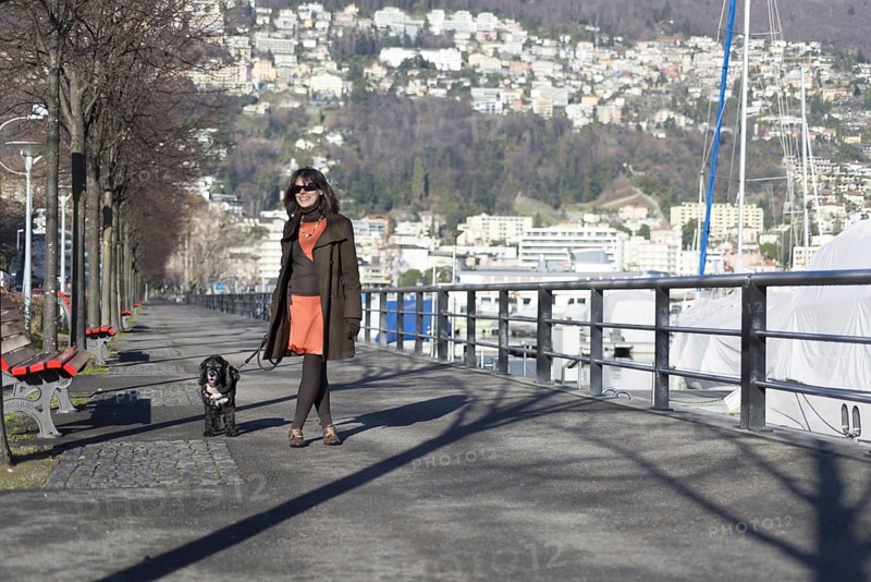 Woman Walking with Her Dog on the City Street in a Sunny Day in Locarno, Ticino, Switzerland, Europe