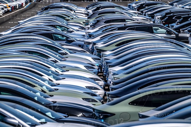 Storage area for new cars in the port of Vlissingen-Oost, vehicles are temporarily stored on over 100 hectares to ship them from Europe to the United Kingdom, Ford cars, others such as models from the Chinese car manufacturer BYD are delivered from here in Europe, wind farm, Netherlands