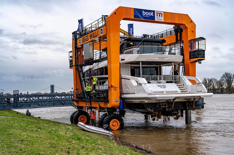 Craning the €6.3 million Sunseeker 88Y motor yacht, weighing 82 tonnes, in preparation for the world's largest water sports trade fair, Boot in Düsseldorf, luxury yachts are driven across the Rhine to the trade fair and brought ashore with the help of the Big Willi ship crane and transported to the exhibition halls on a low-loader, North Rhine-Westphalia, Germany, Europe
