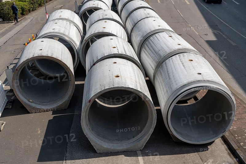 Concrete sewer pipes, stored on a construction site during sewer renovation work, on the Dickswall, city centre of Mülheim an der Ruhr, North Rhine-Westphalia, Germany, Europe