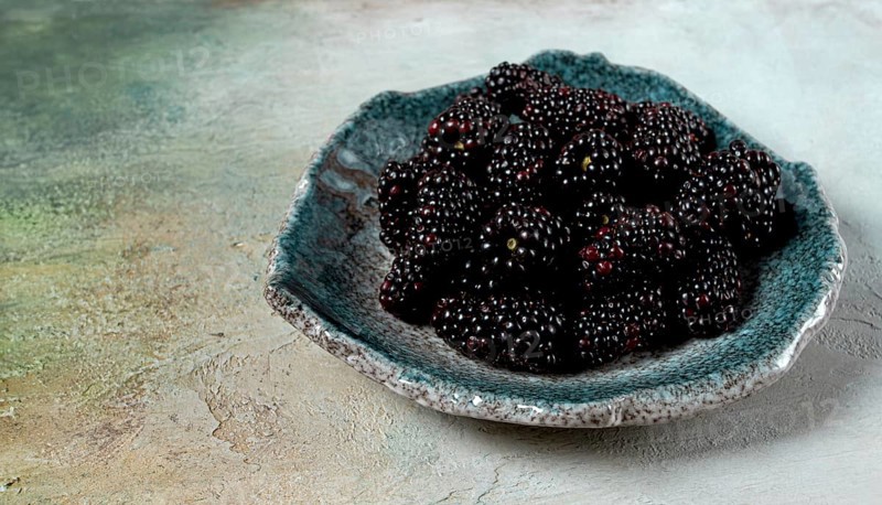 Fresh blackberry berry, on a plate, top view, no people