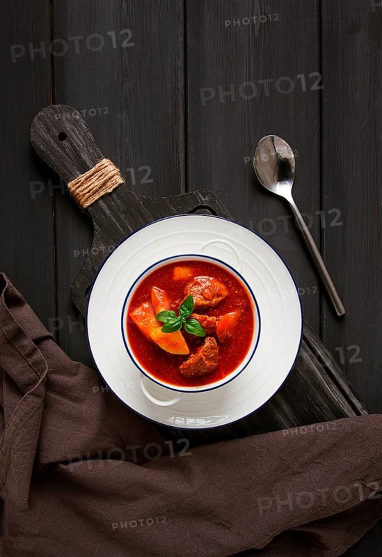 Stew with potatoes, in tomato sauce, with spices and herbs, close-up, no people, on a black background
