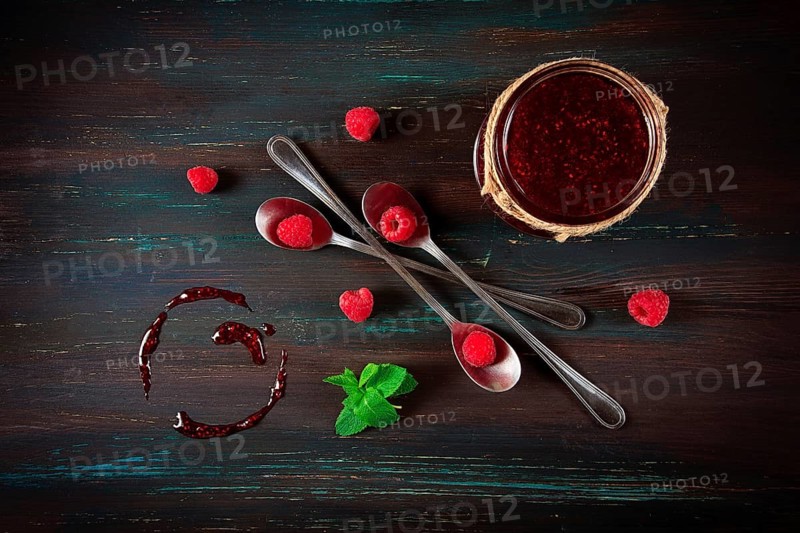 Raspberry jam, on a dark wooden background, top view, selective focus, food concept, no people