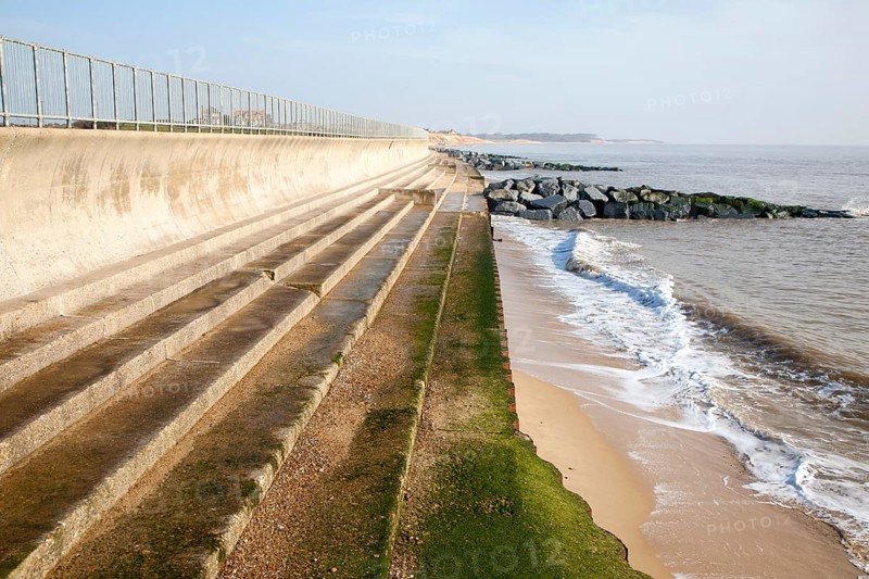 Curved Sea wall, steps and rock armour groynes, forming coastal defences at Southwold, Suffolk, England, United Kingdom, Europe
