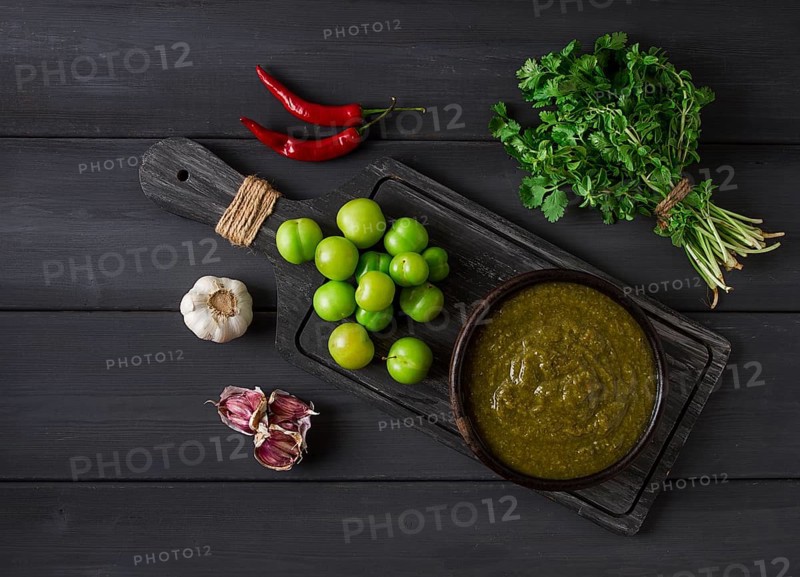 Tkemali sauce, traditional Georgian cuisine, green cherry plum, with ingredients for sauce, cilantro, mint, hot pepper, garlic, on a wooden table, close-up, rustic, food background, no people, selective focus, sauce, green sauce, tkemali, georgian cuisine, homemade