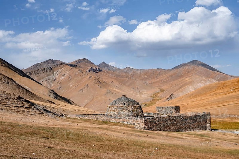 Historic caravanserai Tash Rabat from the 15th century, with yellow hills, Atbashy district in the Naryn region, Kyrgyzstan, Asia