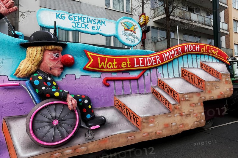 Wheelchair user in jester's costume waiting in front of steps, papier-mâché figure, motif float on the theme of accessibility, Rose Monday parade Düsseldorf, North Rhine-Westphalia, Germany, Europe