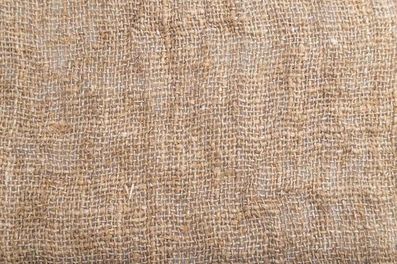 Fragment of smooth brown linen tissue. Top view, flat lay, natural textile background and texture