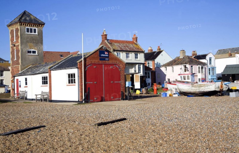 Fishing boats on the beach, Aldeburgh, Suffolk, England. Disused lifeboat building and look out tower