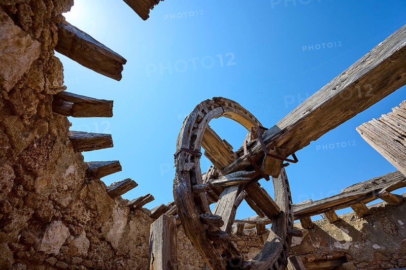 Abandoned building with an old wooden wheel and dilapidated stone walls under a clear blue sky, windmill, ruin, near Lindos, Lindos, Rhodes, Dodecanese, Greek Islands, Greece, Europe
