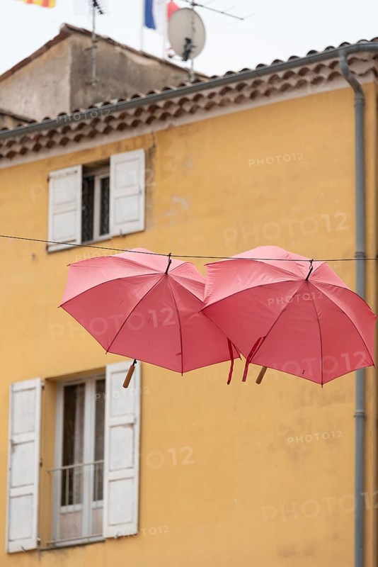 In the perfume town of Grasse, two red umbrellas hang between the houses, Grasse, Provence-Alpes-Côte d'Azur, France, Europe