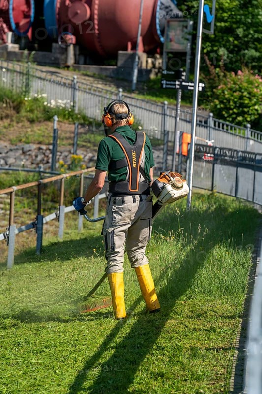 Man mowing a meadow with a brush cutter