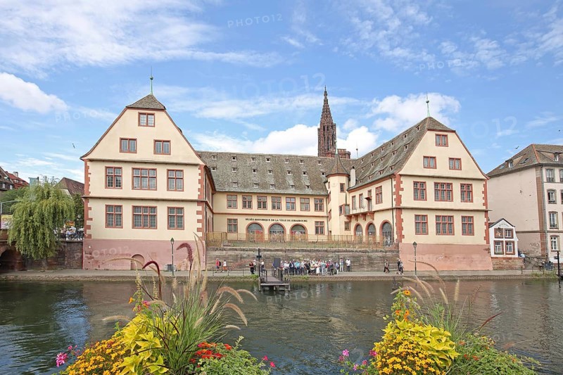 Musée historique, historical museum and river Ill with floral decoration, church tower of the UNESCO cathedral, Grande Île, Strasbourg, Bas-Rhin, Alsace, France, Europe