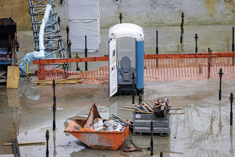 Symbolic photo on the subject of the shortage of skilled labour. A porta-potty with an open door stands on a deserted construction site. Berlin, 09.02.2024