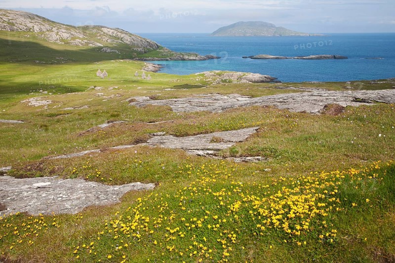 View over machair grassland to abandoned croft houses in the deserted village of Eorasdail, Vatersay Island, Barra, Outer Hebrides, Scotland, UK