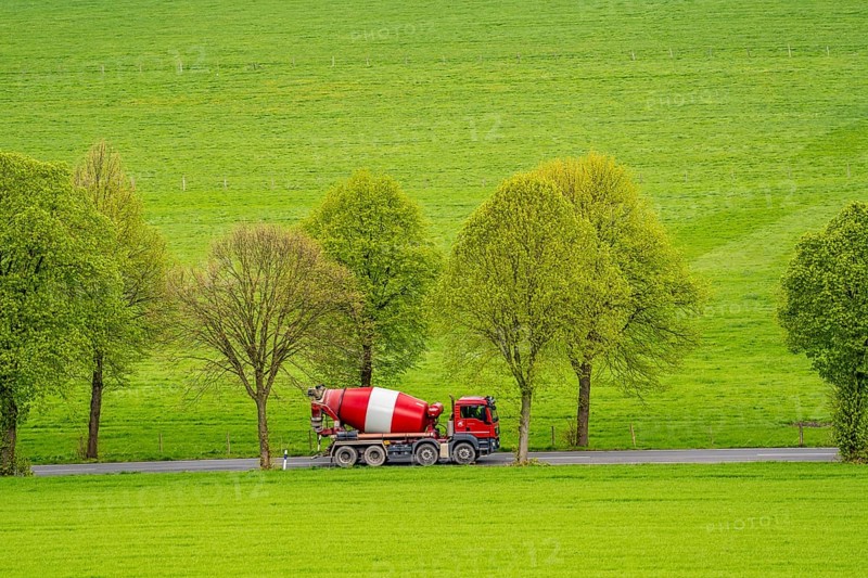 Concrete mixer truck on a country road, green fields, meadows, trees line the 2-lane road, spring, near Schwelm, North Rhine-Westphalia, Germany, Europe