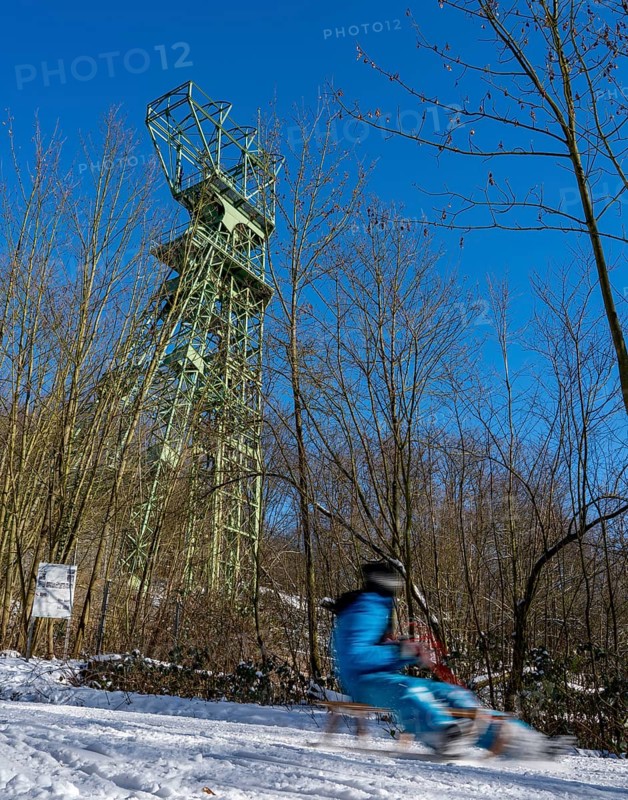 Winter in the Ruhr area, toboggan run on a forest path at Lake Baldeney, headframe of the former Carl Funke colliery, Essen, North Rhine-Westphalia, Germany, Europe